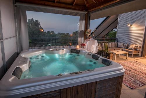 a jacuzzi tub in a room with a balcony at 4 Elements צימר ארבעת היסודות in Rosh Pinna