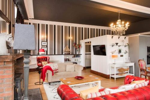 sala de estar con muebles de color rojo y chimenea en The Merryburn - Rooms and Courtyard Studios, en Dunkeld