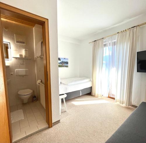 uma pequena casa de banho com um WC e uma janela em Haus Waltraud em Bad Wiessee