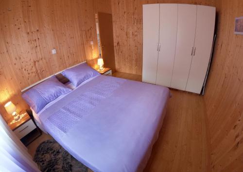 a small bedroom with a large bed and a cabinet at Spignoviza in Kanfanar
