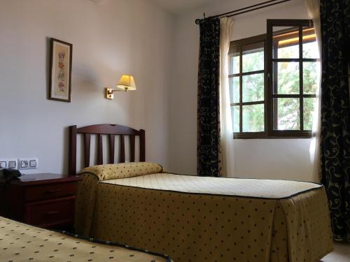 a bedroom with a bed and a window at Hotel Atalayas Extremadura in Zafra