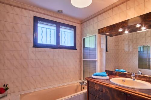 a bathroom with a sink and a tub and a mirror at Villa De Marchi in Saint-Just-de-Claix