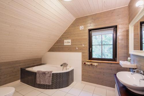 a bathroom with a bath tub and a sink at Dom Black&White in Kołczewo