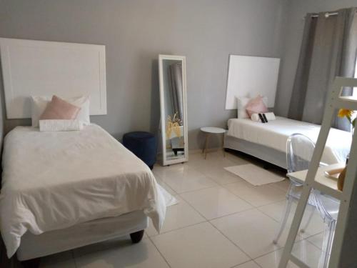 a bedroom with two beds and a mirror at AGT Guesthouse in Vryheid