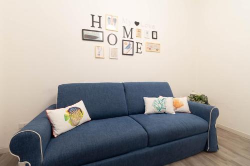 a blue couch in a room with pictures on the wall at Le Casette Di Osvaldo in Lecco