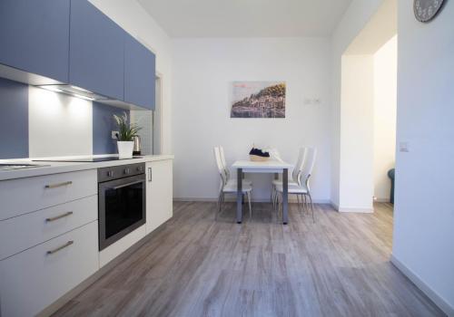 a kitchen with a table and a dining room with white walls at Le Casette Di Osvaldo in Lecco