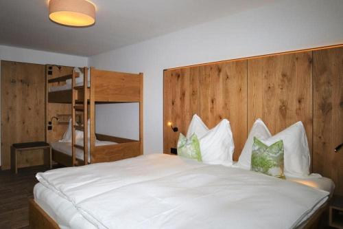 a bedroom with a large white bed with a wooden headboard at Apartment in Bramberg near Cable Car in Bramberg am Wildkogel