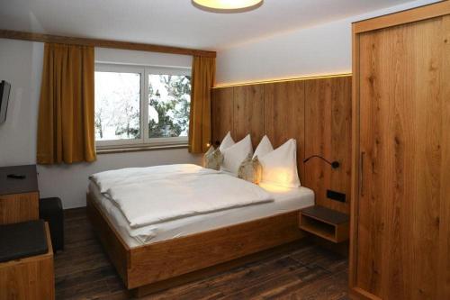 a bedroom with a large white bed with a window at Apartment in Bramberg am Wildkogel with terrace in Bramberg am Wildkogel