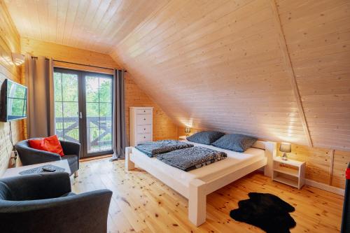 a bedroom with a bed in a room with wooden walls at Dom Black&White in Kołczewo