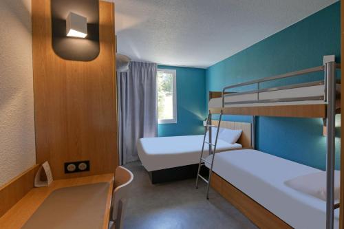 ユサックにあるB&B HOTEL Brive-la-Gaillardeの二段ベッド2台、窓が備わる小さな客室です。
