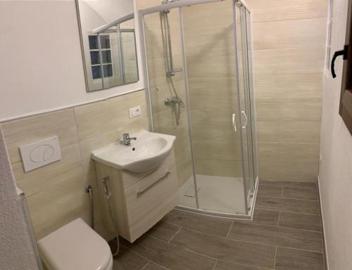 La salle de bains est pourvue d'une douche, d'un lavabo et de toilettes. dans l'établissement Appartamento incantevole La Grotta, à Apricale