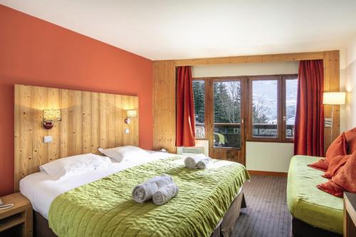 a hotel room with a bed with towels on it at Hôtel Les Menuires Les Bruyères in Les Menuires