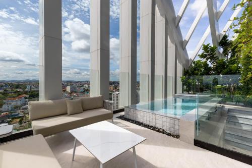 a living room with a pool in a building at Arbour Hotel and Residence in Pattaya Central