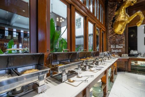 a row of food stations in a restaurant at True Siam Phayathai Hotel in Bangkok