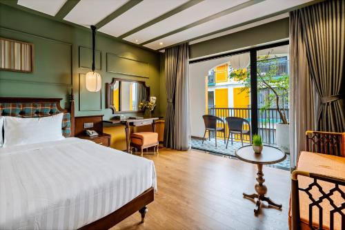 a bedroom with a bed and a desk and a table at Son Hoi An Boutique Hotel & Spa in Hoi An