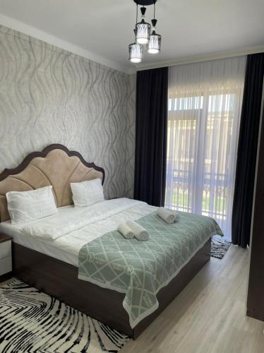 1 dormitorio con 1 cama con 2 toallas en KERUEN SARAY APARTMENTS 27/2 en Türkistan