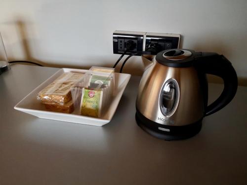 a tea kettle and a tray of food on a table at Magic Place Bergamo! Relax Apartment with terrace in the heart of the city in Bergamo