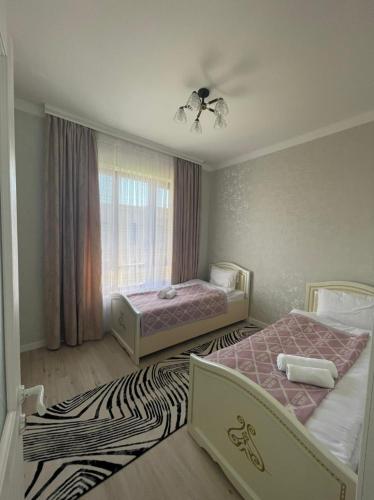 a bedroom with two beds and a zebra rug at KERUEN SARAY APARTMENTS 27/2 in Türkistan