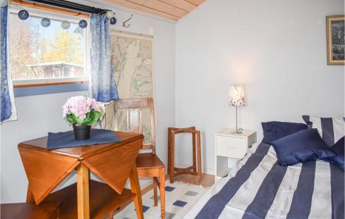 um quarto com uma cama e uma mesa com flores em Stunning Home In Motala With Kitchen em Motala