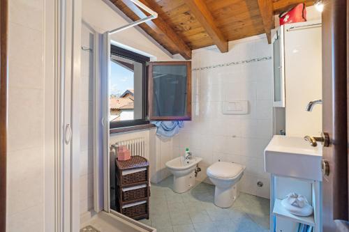 baño con aseo y lavabo y ventana en La Casa di Annibale, en Massino Visconti
