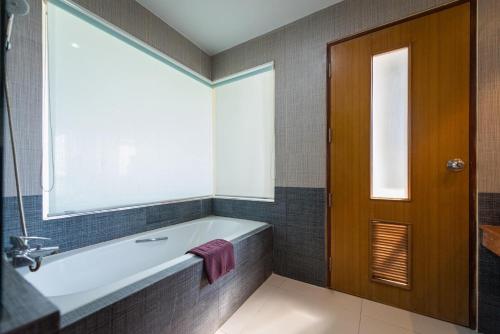 佛統的住宿－Uniland Golf & Resort，带浴缸的浴室和窗户。