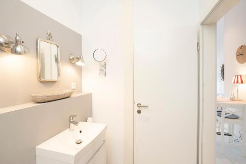 a white bathroom with a sink and a shower at Golfplatz Plöner See "Kleiner Plöner See" in Bosau