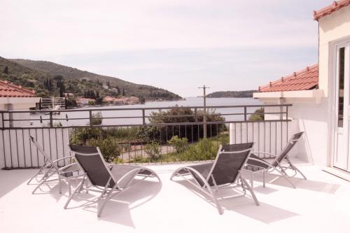balcón con sillas y vistas al agua en Guest House Kukuljica 2, en Zaton