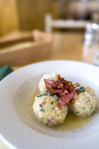a white plate with two muffins with bacon and gravy at Rifugio Chierego - 1911m in Brenzone sul Garda