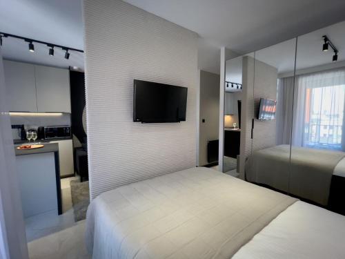 1 dormitorio con 1 cama y TV de pantalla plana en URBAN APARTMENTS PREMIUM DOWNTOWN Opolska 10 No 89 with GARAGE, en Katowice