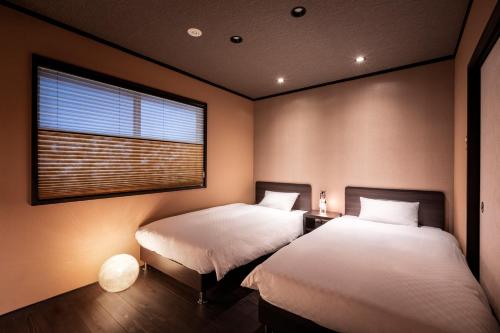 2 camas en una habitación con ventana en Rinn Manjuji en Kioto