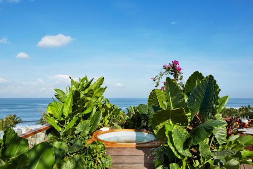 a view of the ocean from a garden with plants at Potato Head Suites & Studios in Seminyak