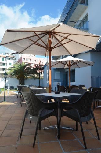 a group of tables and umbrellas on a patio at Madeira Bright Star by Petit Hotels in Funchal