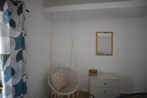 a white room with a chair and a mirror at Kite Hostel Stagnone in Marsala
