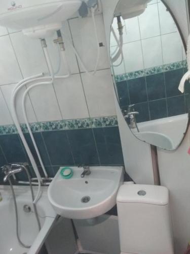 a bathroom with a sink and a toilet and a mirror at Уютная 1 комнатная квартира возле метро Дарница in Kyiv