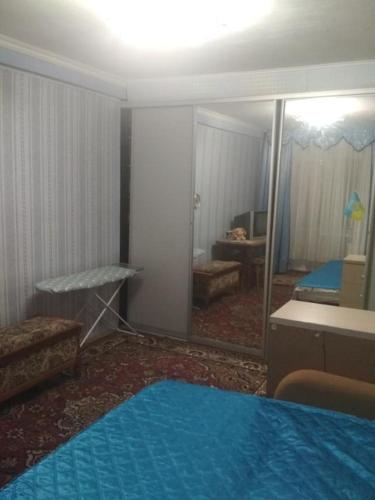 a room with a mirror and a bedroom with a bed at Уютная 1 комнатная квартира возле метро Дарница in Kyiv