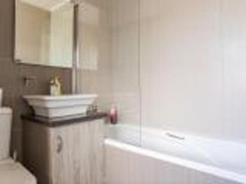 a bathroom with a tub and a sink and a mirror at Bedfordview Haven in Johannesburg