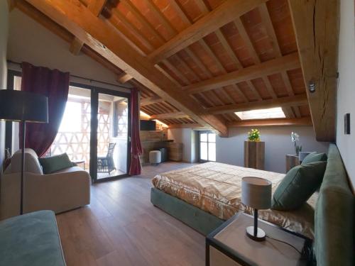 1 dormitorio con 1 cama y 1 sofá en una habitación en Relais Colle Messino Briaglia Mondovì, en Mondovì