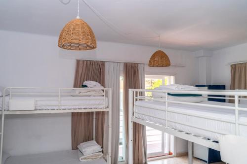 um quarto com três beliches e duas luzes pendentes em La Moraga de Poniente Malaga Hostel em Málaga