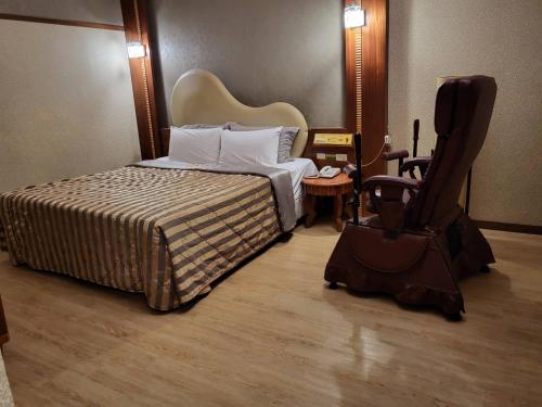 Habitación de hotel con cama y silla en Chateau Motel & Spa - Nanzi, en Liugui