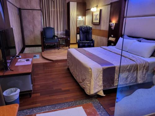 a hotel room with a bed and a desk at Chateau Motel & Spa - Nanzi in Liugui