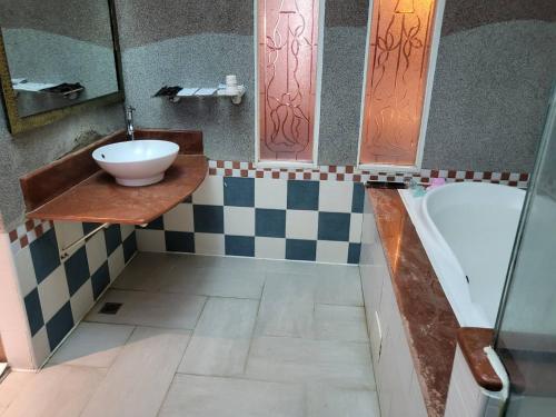 ein Badezimmer mit einem Waschbecken und einer Badewanne in der Unterkunft Chateau Motel & Spa - Nanzi in Liugui