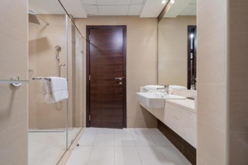 a bathroom with two sinks and a shower and a mirror at EDEN'S Homes & Villas - Sparkle Tower in Dubai