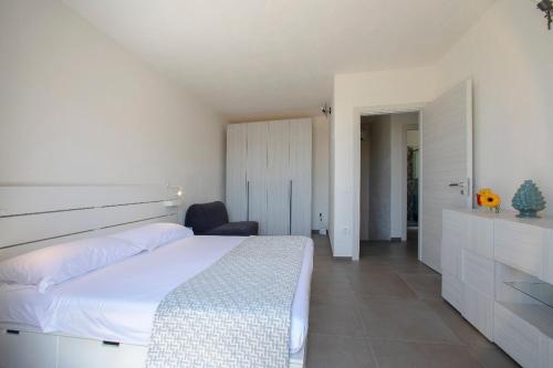 a bedroom with a large white bed and a desk at 18 Gradi Apartments in Marsala