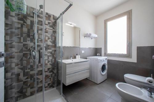 a bathroom with a shower sink and a washing machine at 18 Gradi Apartments in Marsala
