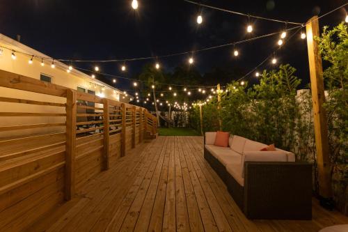 a patio with a couch on a deck with lights at Art Deco Themed Vacation Home w Sauna, Huge Terrace, & Outdoor BBQ Kitchen in Hallandale Beach