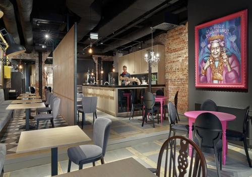 un restaurante con mesas y sillas y un chef en la cocina en HOLA GDYNIA en Gdynia