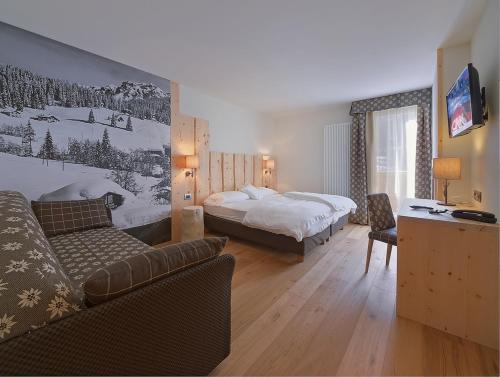 a hotel room with a bed and a couch at Chalet Degli Angeli in Folgarida