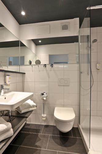 a bathroom with a toilet and a sink and a shower at AktiVital Hotel in Bad Griesbach