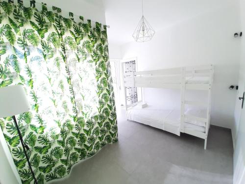 una camera con un letto a castello bianco e una tenda verde di Otranto Casetta del Turchese a Otranto