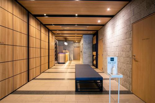 a hallway with a table and a bench in a building at Minn Nishi Kasai in Tokyo